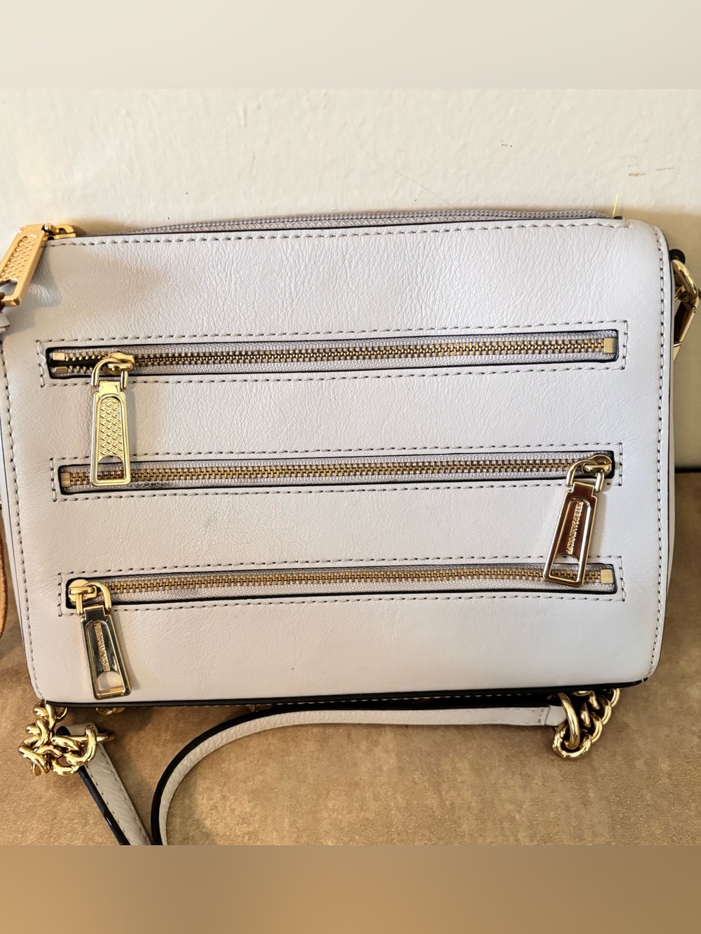 Rebecca Minkoff cream 5 Zip crossbody bag featuring gold-toned hardware.